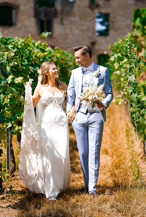 Brautpaar beim Hochzeitsshooting, läuft Hand in Hand und schaut sich an